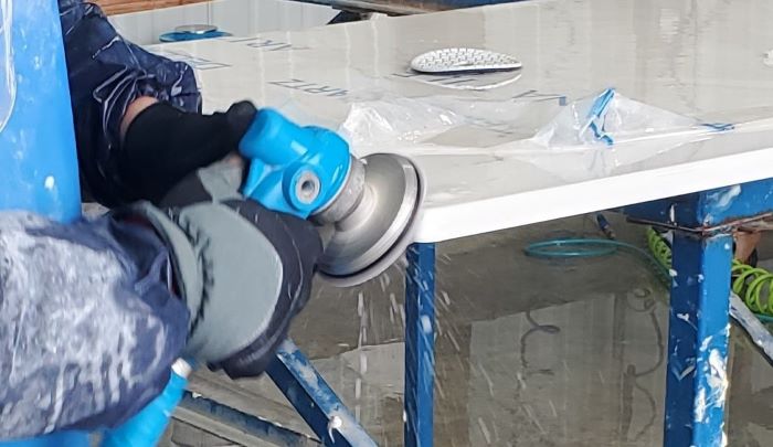 Worker sanding an engineered stone countertop