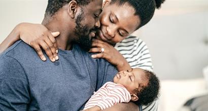 Black couple looking lovingly at their infant