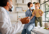 boy and worman in mask in front of male doctor