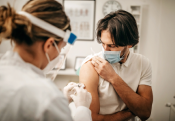 man in mask getting vaccine